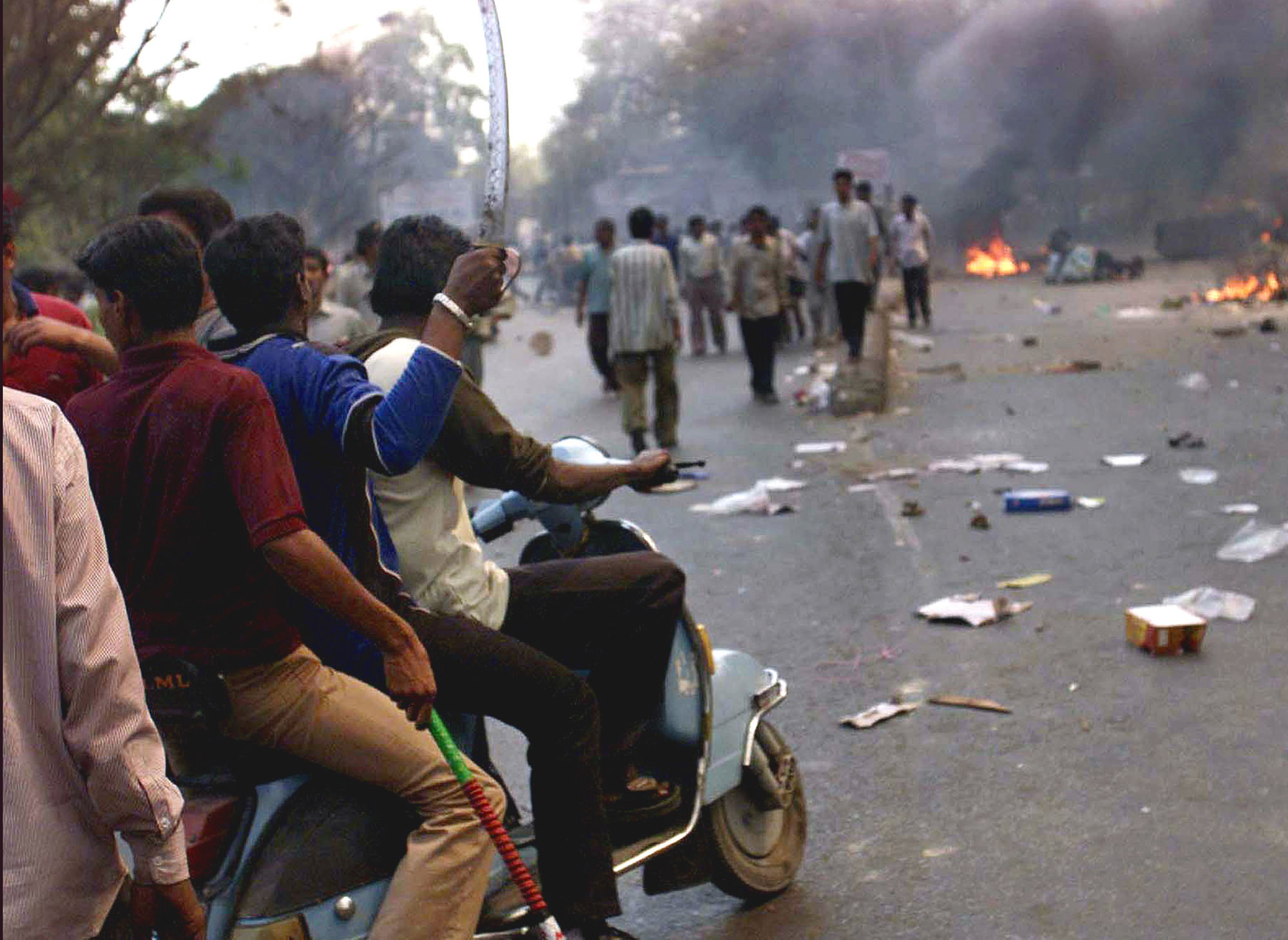 Youths with swords and sticks ride through a street of Ahmadabad, India Thursday, Feb. 28, 2002, a day after a Muslim mob attacked a train, killing 58 people in the Indian state of Gujarat. The city of Ahmadabad was besieged by violence on Thursday to avenge the attack. (AP Photo/Manish Swarup)
