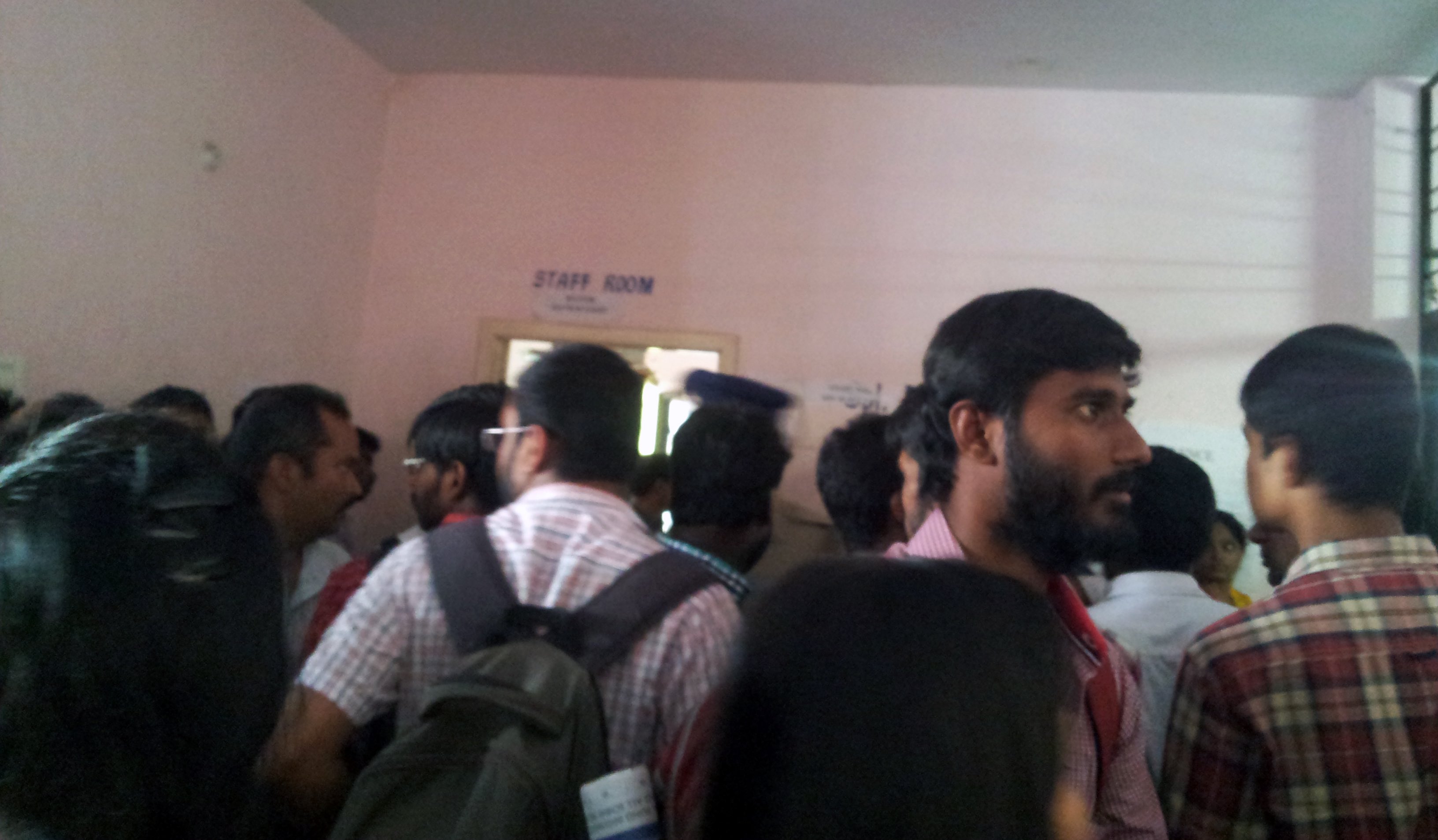 People gather around the doorway of the court (to the right), in order to see what's happening